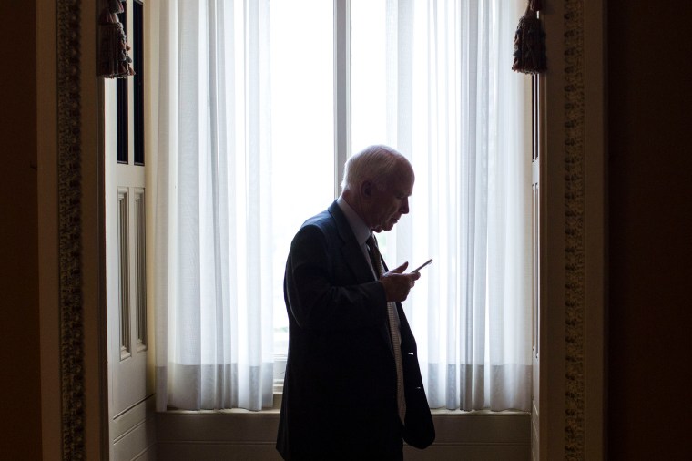 John McCain speaks on the phone as he steps off the senate floor on Capitol Hill, on May 25, 2016, in Washington.