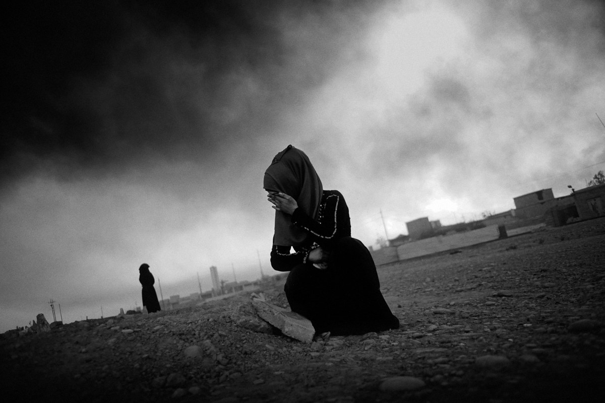 A young woman in grief, cries at her mother grave in the outskirts of the city Qayyara, south of Mosul. She was killed in an airstrike by coalition forces as they backed up Iraqi forces retaking the city from IS. Before leaving the city, IS destroyed all the tombstones in the graveyard. The dense plumes of smoke are emanating from multiple sites about 30 miles (50 km) south of Mosul. The fires were deliberately set by ISIS militants before abandoning the city. The smoke has been persistent over the past three months, blotting out the sun hours before nightfall and creating major health issue for mainly the children in the area.