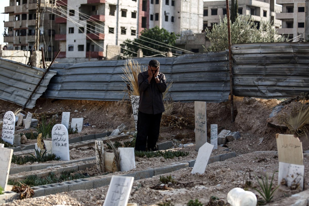 Abu Omar al-Ghoosh, who reportedly lost 17 relatives in a chemical attack, prays at a cemetery in Zamalka on Aug. 21. Mohammed BadraÃ¢Â€Â”EPA