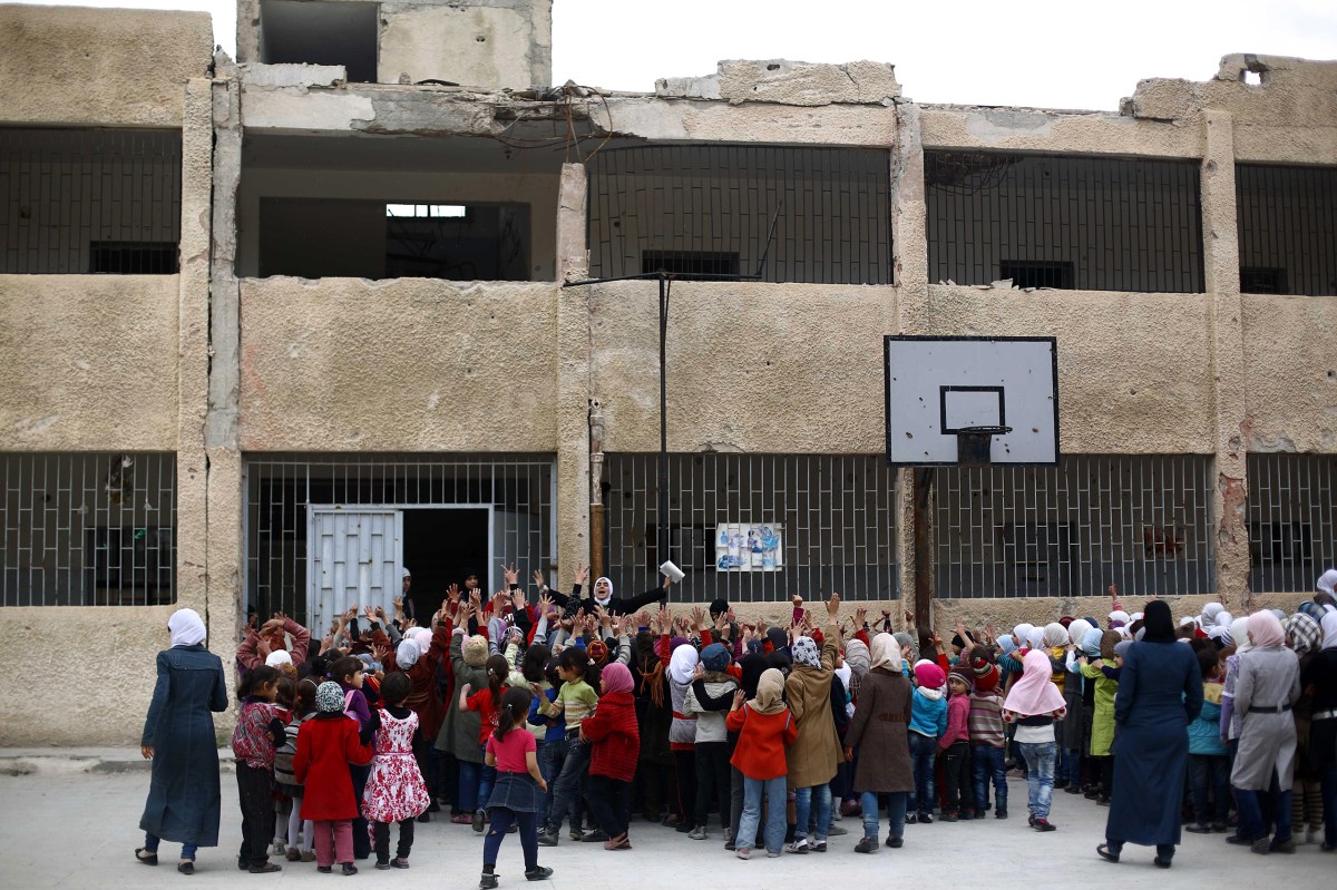 Children gather at a schoolyard in Douma on April 12, after a ceasefire in February allowed many students to return to school. Mohammed BadraÃ¢Â€Â”EPA