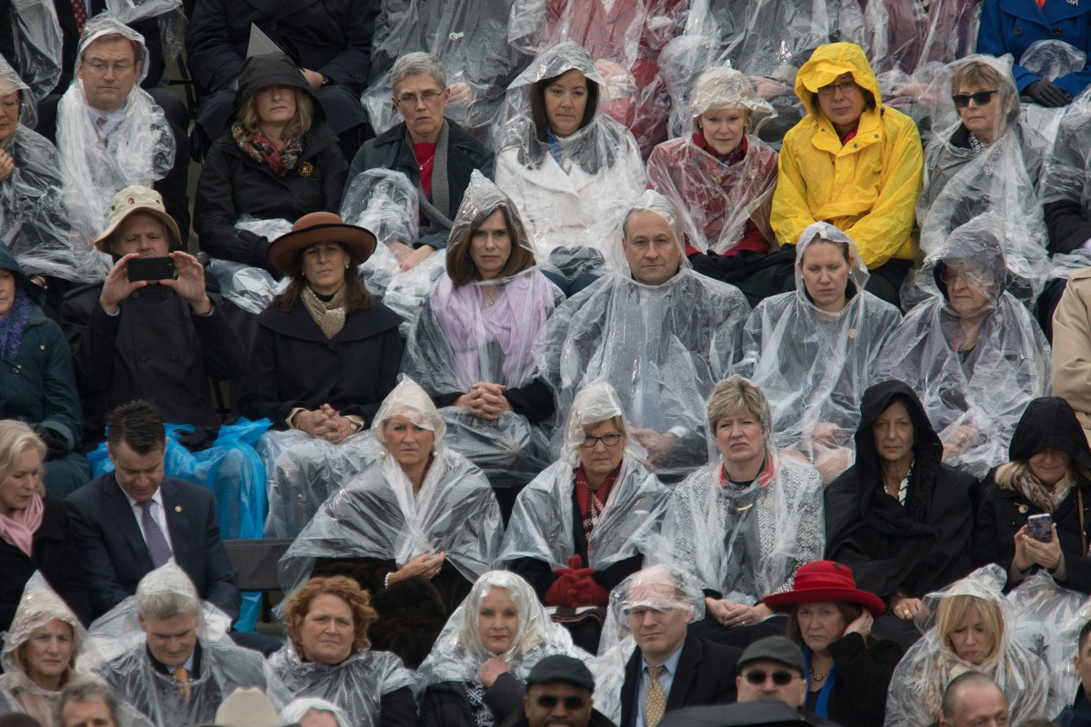 Attendees of President Trump's inauguration ceremony sit in the rain on Capitol grounds in Washington, D.C., on Jan. 20, 2017.