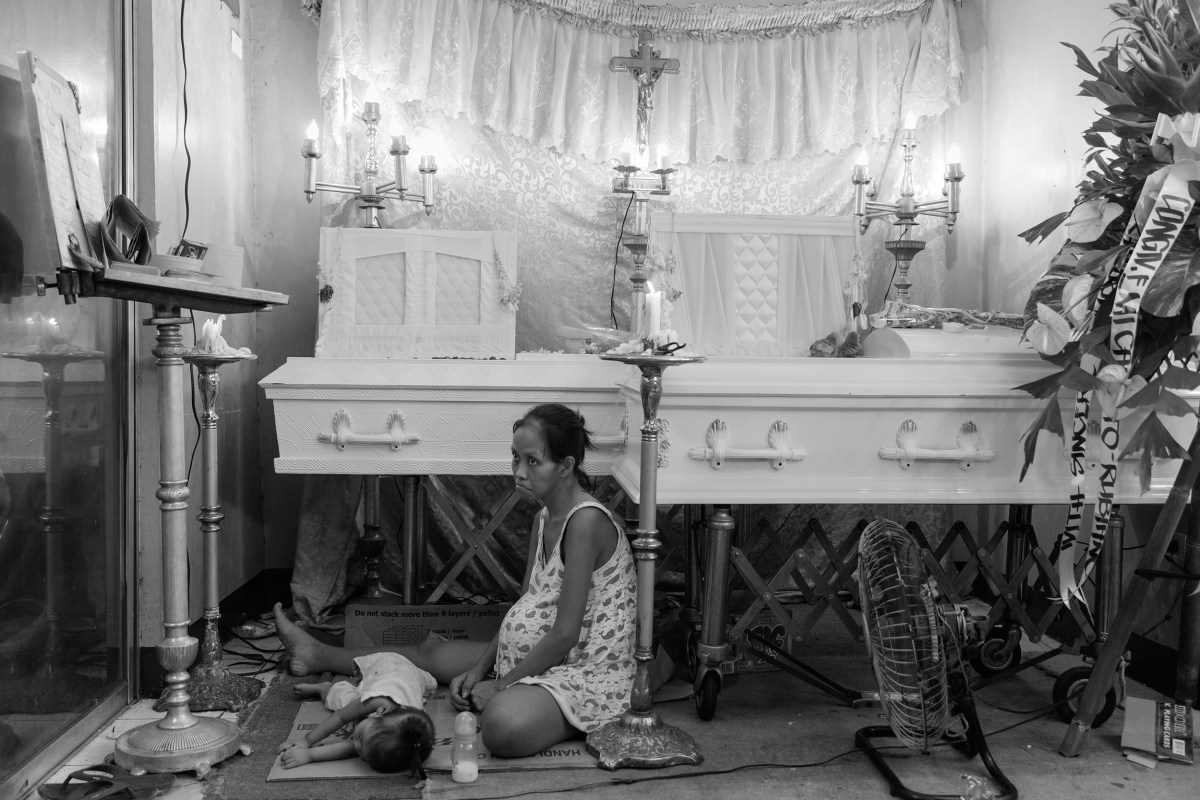 The coffins of Domingo MaÃƒÂ±osca and son Francis, 5, on Dec. 14. Both were killed by shots fired through the plywood window of their tiny Manila home. Elisabeth Navarro, nine months pregnant, survived with Erika, 1, and a second girl