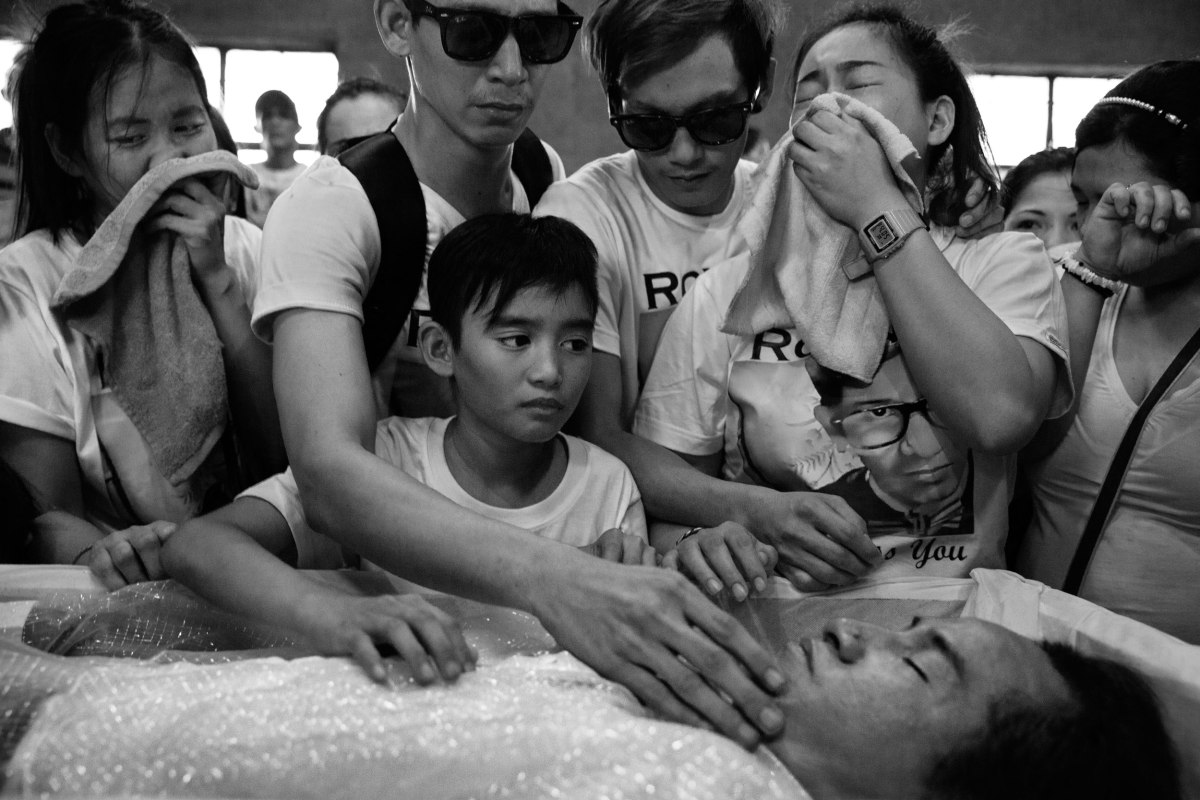 Family members grieve for Ronnie Arroyo in Quezon City on Dec. 6. Arroyo, 36, was a drug user killed in an abandoned house by police who claimed he fired first