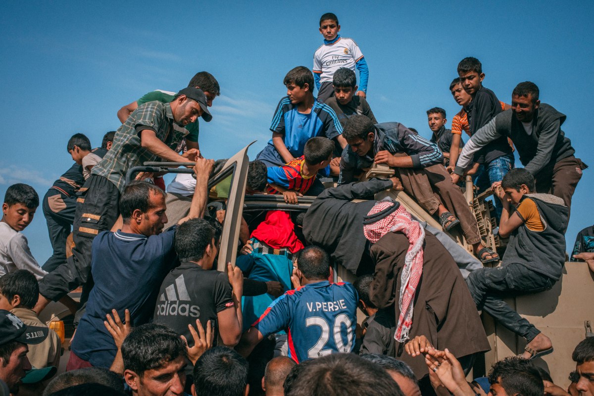 Displaced Mosul residents swarm an aid truck at Hammam al-Alil camp southwest of the city on April 6.