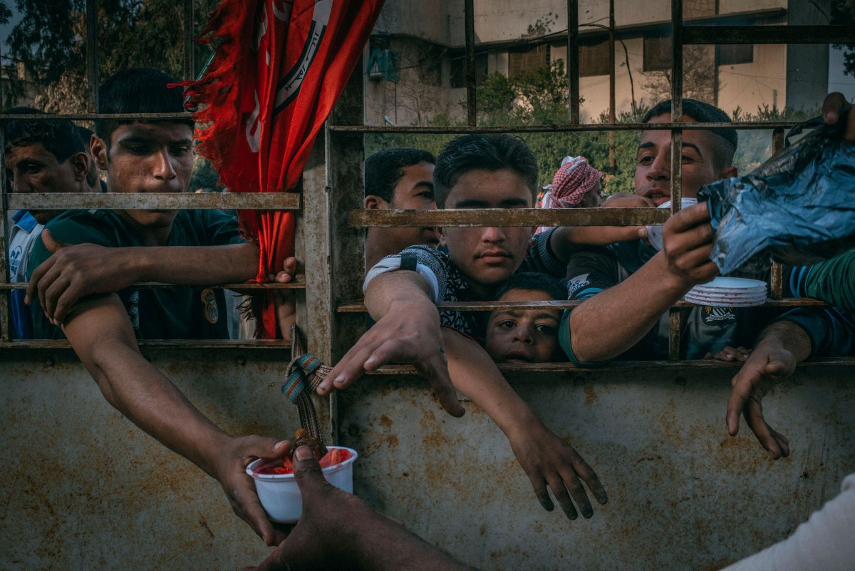 Iraqis wait for food distribution in Mosulâ€™s Aqeedat neighborhood on March 29.