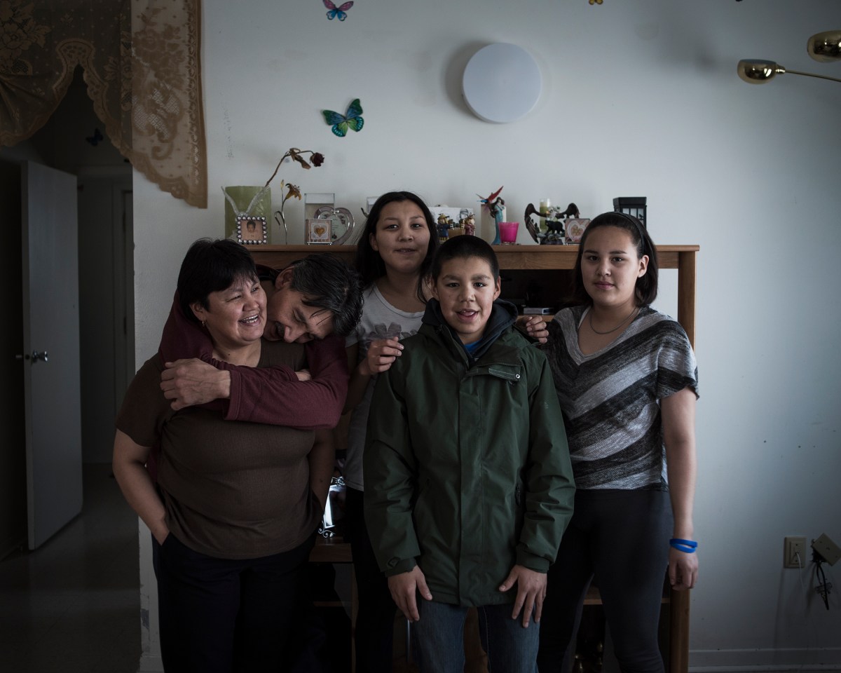 The Natanine family inside their living room in Clyde River, Nunavut. Christine Natanine (left) runs Ilisaqsivik, which offers counseling and mental health care to Inuit residents. Her husband, Jerry Natanine, (second from left) is the former mayor of Clyde River, and one of the most vocal proponents of protecting indigenous ways of life in the community. 