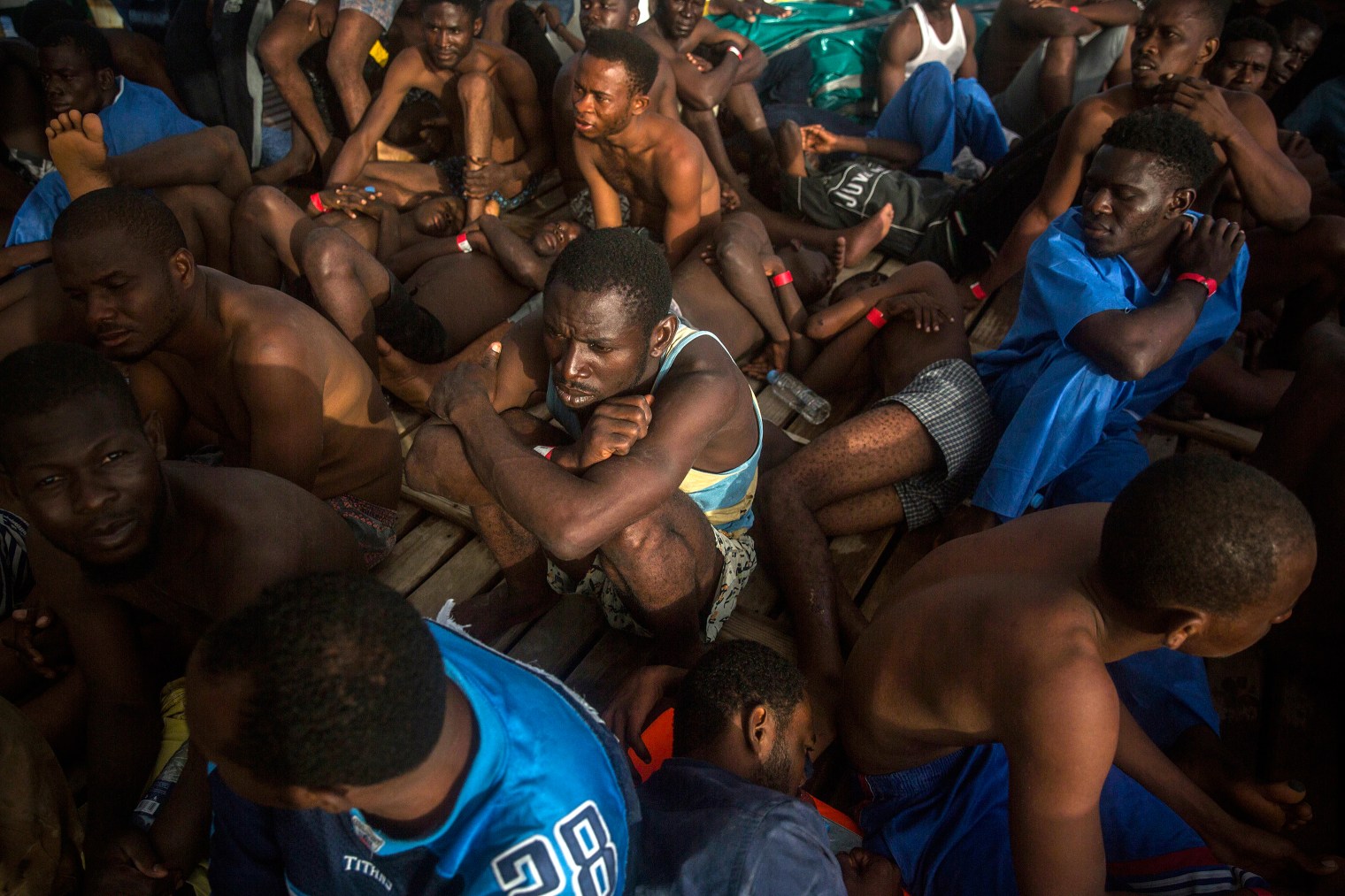 Migrants sit on the deck of the Open Arms vessel after their rescue.