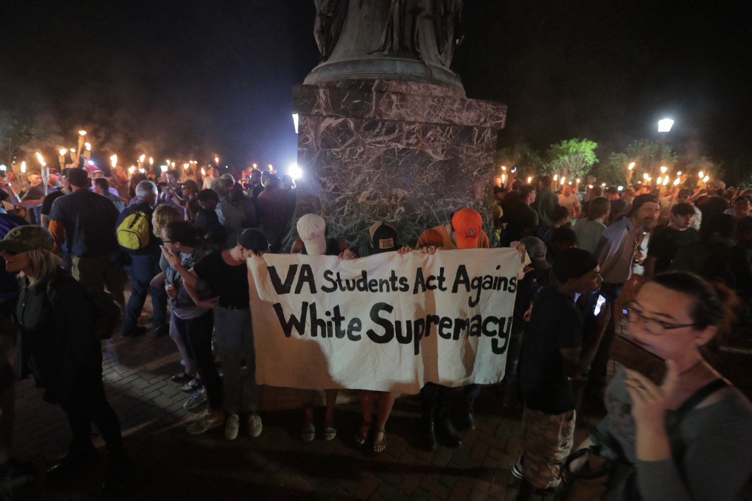 A group of counter-protesters against the white nationalists who gathered on the University of Virginia campus stand at the base of a Thomas Jefferson statue in Charlottesville, Va., on Aug. 11, 2017.