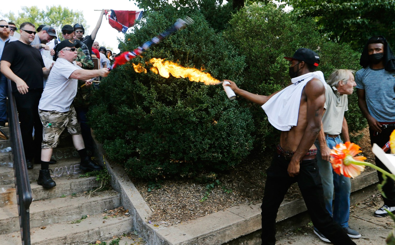  counter-demonstrator uses a lighted spray can against a white nationalist demonstrator at the entrance to Lee Park in Charlottesville, Va., on Aug. 12, 2017.