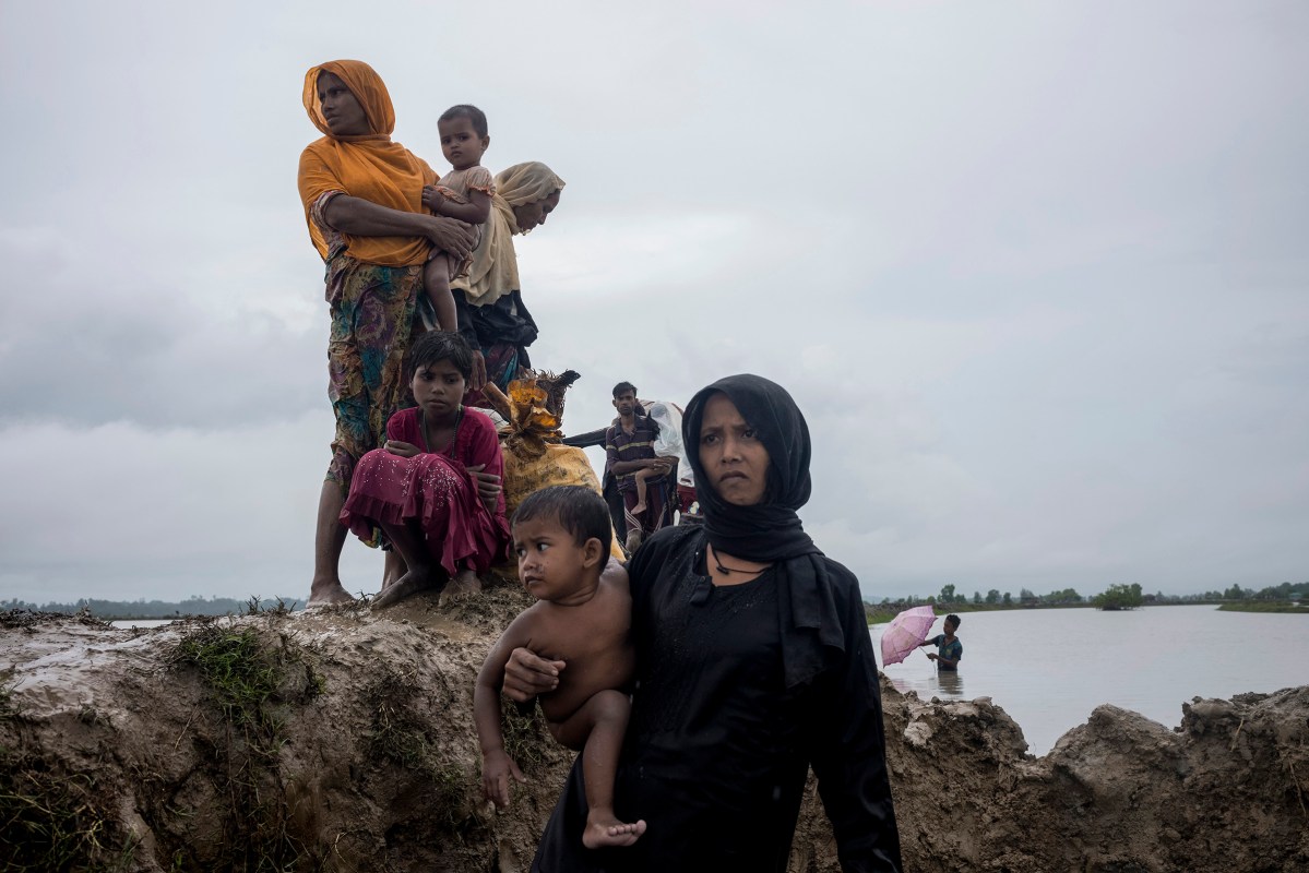 Members of Myanmar's Rohingya ethnic minority walk in flooded land after crossing the border into Bangladesh, September 1, 2017.