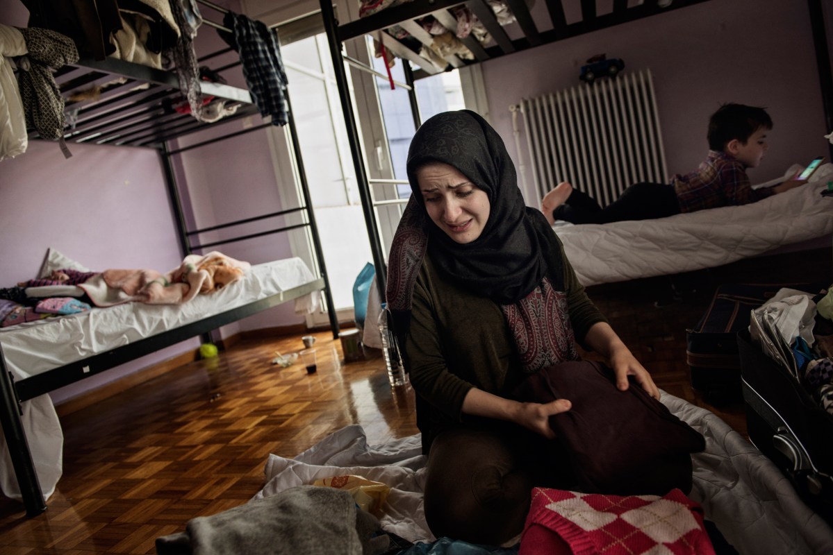 Syrian refugees TaIma Abzali, her husband Muhanned Abzali, their six month old daughter, Heln, and son Wael, pack their memories and belongings the night before leaving for relocation in Estonia, April 19, 2017. Taima was overcome with emotion, a nostalgia for Syria, and missing her family, as she packed. (Credit: Lynsey Addario for Time Magazine)
